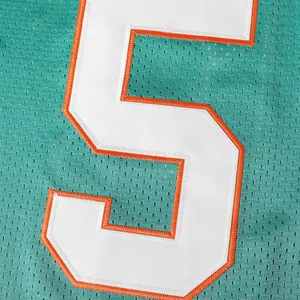 Nahaufnahme der gestickten weißen Nummer 5 mit orangefarbenem Rand auf dem Football-Trikot
