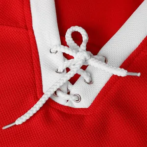Close-up of retro red ice hockey jersey showing white lace-up V-neck detail and eyelets.