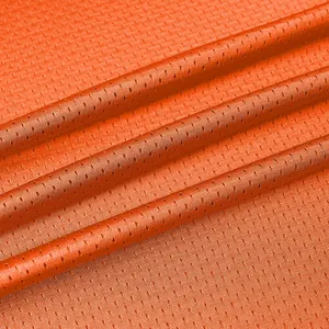 Detailed macro view of orange breathable mesh fabric used for athletic sports jerseys