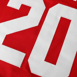 Detailed close-up view of embroidered white number 20 on red hockey jersey fabric