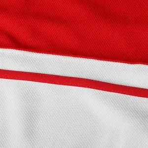 Detailed view of the red and white breathable mesh fabric and seams on a hockey jersey.