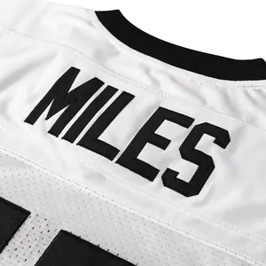 Macro view of embroidered MILES text on back of white mesh American football jersey