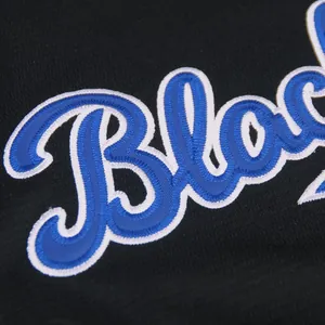 Close-up detail of blue and white text embroidery on a black vintage baseball jersey.