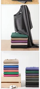 Stacked vintage washed cotton t-shirts in various colors on wooden crates with cotton.