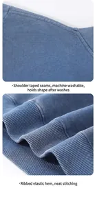 Détail d'un sweat à capuche bleu délavé vintage avec ourlet côtelé et coutures renforcées.