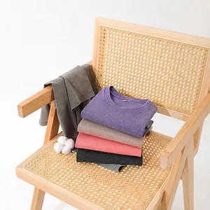 Stapel van 230g zwaar gewassen distressed t-shirts in meerdere kleuren op een stoel