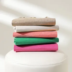 A stack of 230g heavy washed distressed cotton t-shirts shown in multiple vibrant colors