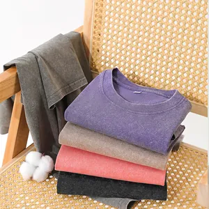 Premium 230g washed cotton distressed t-shirts stacked on a wooden rattan chair