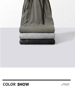 Detailed view of stacked vintage washed cotton joggers in olive, grey, and black colors