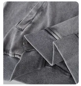 Dettaglio di felpa con cappuccio 320G in cotone lavato con polsini a coste e zip.