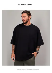 Man wearing a 300g oversized heavy cotton drop shoulder crew neck T-shirt in black