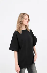 Female model wearing an oversized black 180g cotton T-shirt in a professional studio setting