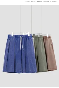 Close-up of three pairs of vintage washed cotton shorts in blue, green, and brown