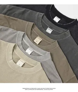 Close-up detail of several washed earth-tone heavy cotton T-shirts showing size labels.