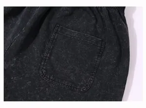 Detailed macro shot of patch pocket on vintage black acid-washed heavy cotton shorts