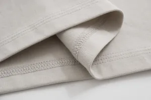 Close-up macro view of high-quality three-needle stitching on a pure cotton T-shirt hem