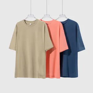 Τρία vintage πλυμένα βαμβακερά t-shirts σε χακί, κοραλλί και μπλε σε λευκό φόντο.
