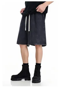 Detail view of washed distressed black cotton sweat shorts with white drawstrings