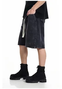 Detailed side view of vintage washed black cotton shorts for men with a white drawstring