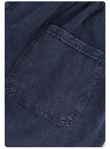 Detailed macro view showing the pocket and fabric of washed blue vintage cotton shorts.