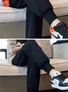Detailed close-up showing the soft fabric and cuffed ankle design of black joggers on a sofa