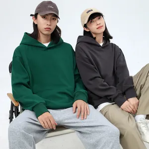 Couple wearing oversized heavyweight fleece hoodies with front pocket in outdoor style