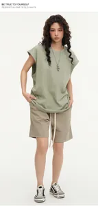 Professional full-body shot of a sage green oversized sleeveless tee and khaki shorts