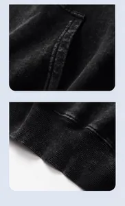 Detailed close-up showing the pocket and ribbed hem of a vintage washed black hoodie