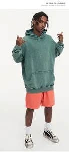 Close-up detail of a vintage washed 450G heavyweight green hoodie on a male model.