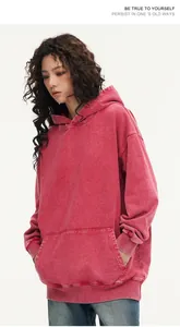Detailed view of a heavyweight 450g washed red cotton hoodie with an oversized fit.