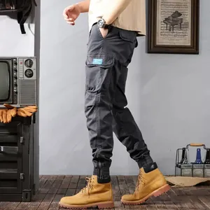 Detail of dark grey retro washed cargo joggers with tapered cuffs and side pockets.