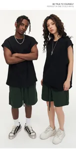 Full-body view of models wearing oversized black sleeveless tank tops and dark green shorts.