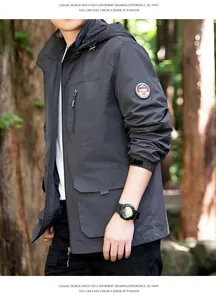 Macro view of men's windproof hooded outdoor jacket with arm badge in a forest scene