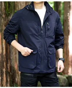 Detail of men's navy blue windbreaker hooded jacket worn by model in a forest