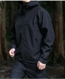 Gros plan d'une veste softshell noire à capuche dans une forêt extérieure