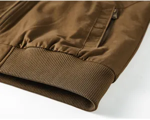 Close-up detail of a brown washed cotton flight jacket showing the ribbed hem texture