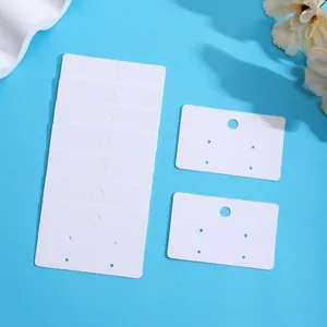 Detailed macro view of blank white paper earring display cards with pre-punched holes