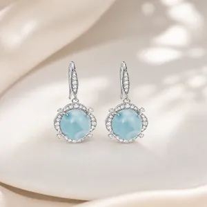 Primer plano de elegantes pendientes de piedra azul claro con pernos de plata S925
