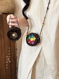 Detalle del monedero tejido bohemio con botones de corazón coloridos y coco natural