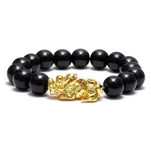 Detail shot of a men's black obsidian bead bracelet featuring a gold Pi Xiu mythical charm.