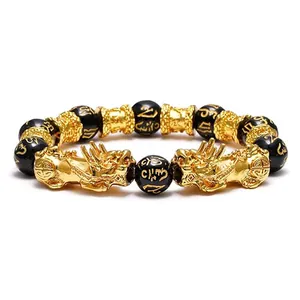 Detailed view of obsidian beads with gold Pixiu charms and Six-character Mantra symbols