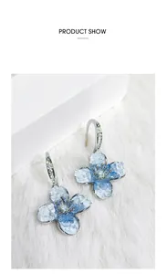 Vista detallada de los pendientes de flores azul degradado con pedrería fina