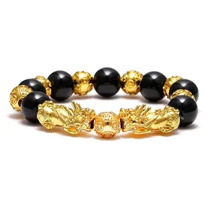 Close-up detail of black obsidian beads and gold-plated Pi Xiu charms on a feng shui bracelet