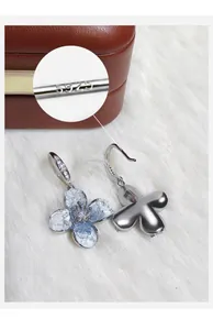 Detalle de pendientes de flor azul degradada con sello de autenticidad de plata S925