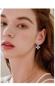 Vista detallada de elegantes pendientes de flores azul degradado usados por una modelo mujer