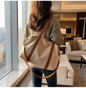 Stylish woman carrying a large beige canvas shoulder bag in a modern hotel lounge