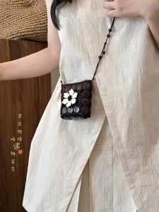 Vista detallada del mini monedero bohemio con flor blanca en cuentas de coco