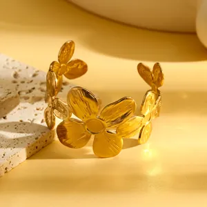 Detailweergave van een goudkleurige roestvrijstalen armband met bloemmotieven in retro