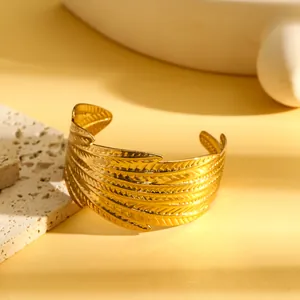 Macro-detail van een vintage gouden roestvrijstalen manchetarmband met bladmotief