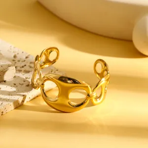 Detailopname van een gouden roestvrijstalen armband met een geometrisch hol design